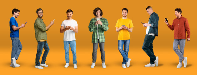 Wall Mural - Cheerful young caucasian men in casual typing on smartphones, watch video