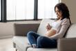 © Prostock-studio - Portrait of young pregnant woman walking with fingers acroos her big belly