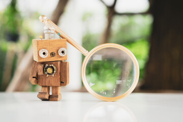 Wooden robot with a magnifying glass, Concept of ​​finding things with technology and AI.
