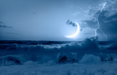Wall Mural - Night sky with crescent moon and lightning in the clouds on the fore ground strong sea wave 