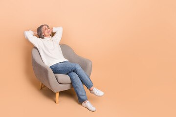 Wall Mural - Full length photo of cute shiny lady dressed white sweater arms behind head closed eyes empty space isolated beige color background