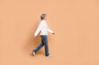 © deagreez - Full length photo of funky adorable lady dressed white sweater walking looking empty space isolated beige color background