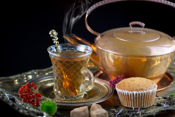 Hot sweet tea in a cup on old background