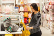 © volurol - Young mother doing shopping in baby shop. Baby fashion, shopping time, sale and pregnancy concept.