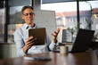 © JustLife - Portrait of businessman in office. Man using digital tablet. Businessman having video call..
