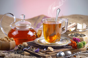 Wall Mural - Sweet, hot tea with dry tea leaves, on an old background.