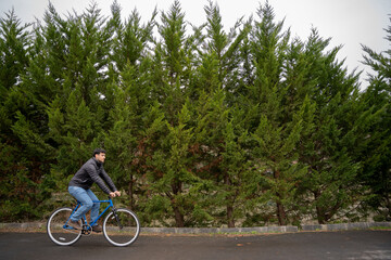 Wall Mural - Man riding a bike in tree background