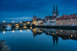 Blick über die Donau auf die Regensburger Altstatt und die steinerne Brücke zur blauen Stunde