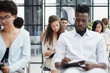 © Katsiaryna - Multi-ethnic group of people while answering questions during training seminar or business conference in office, copy space