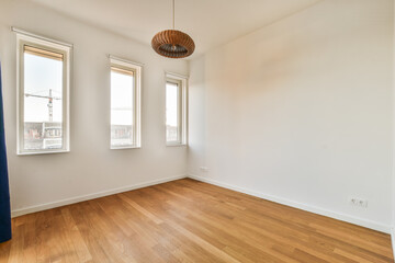 an empty room with wood flooring and two windows looking out onto the cityscapearrons com