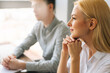© dikushin - Close-up side view face of pretty smiling female hr manager holding job interview with vacancy candidate at meeting in corporate office. Caucasian headhunters having job interview with job seeker