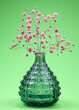 rosa Schleierkraut in grüner Vase vor grünem Hintergrund