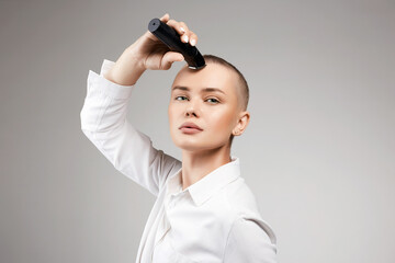 Wall Mural - beautiful young woman cutting her hair. bald Girl with hairclipper