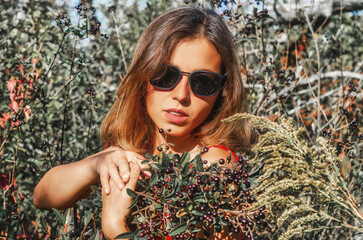 Wall Mural - Pretty woman in sunglasses with branches with black berries