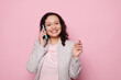 © Taras Grebinets - Multi-ethnic middle-aged woman, successful businesswoman, manager, entrepreneur talking on mobile phone, smiling looking at camera, isolated on pink color background. People. Communication. Business