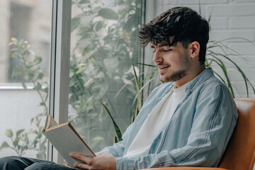 Canvas Print - young man reading a textbook at home