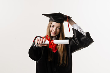 Wall Mural - Masters degree diploma with red ribbon in hands of graduate girl in black graduation gown on white background. Graduate girl is graduating high school and celebrating academic achievement.