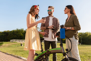 company of friends having fun together in park listening to music