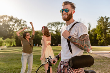 Wall Mural - company of friends having fun together in park listening to music