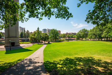 A walking trail through the park alongside the clock tower on a summer day at Riverfront Park, Spokane, Washington USA.