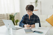 © satura_ - Businesswoman or blogger working on laptop computer sitting at home and managing her business via home office during coronavirus or Covid-19 lockdown. Remote work and blogging concept