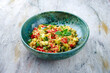Traditional Moroccan vegetable couscous with zucchini and paprika served as close-up on a Nordic Design bowl with copy space