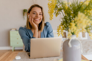 young pretty stylish woman working remote at home at table workplace, student education