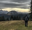Wanderer von hinten an einem bewölkten Tag im Herbst vor einer beeindruckenden Bergkulisse im Heutal, Alpen, Tirol, Österreich