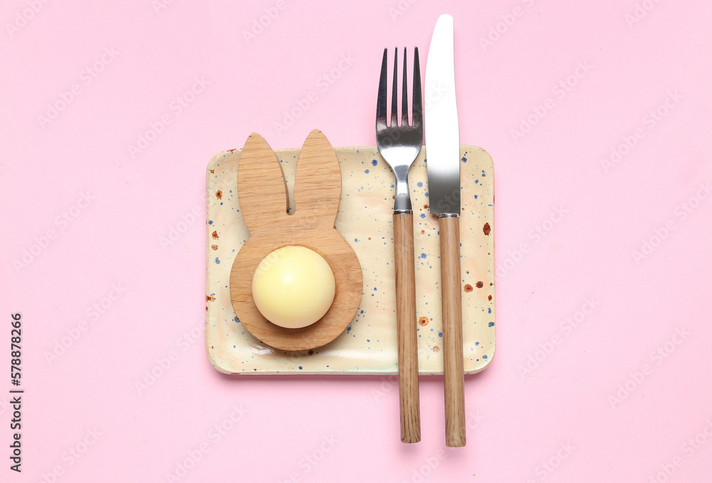 Table setting with Easter egg on pink background