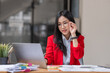 © David - Asian businesswoman analyzing reports while working in workplace office.