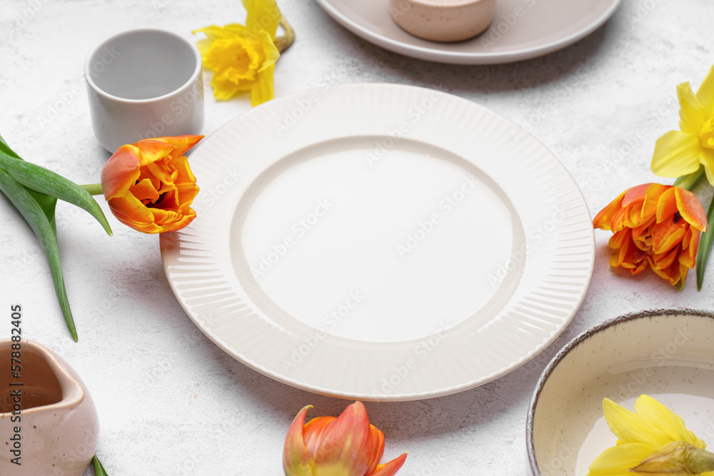 Clean plate and beautiful flowers on white grunge background