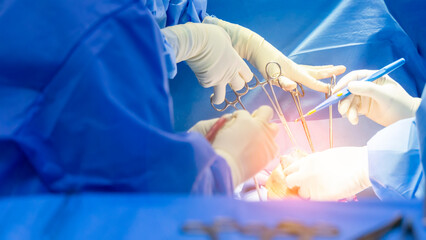 Wall Mural - Panorama banner inside operating room.Doctor and team of nurse doing surgery inside a theatre in hospital.Orthopedic spine surgery with medical instrument.Surgeon in blue sterile uniform in close up.