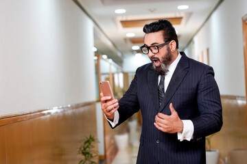 Indian businessman using smartphone at office.