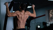 © Михаил Решетников - Back view of shirtless man with pull-ups in gym.