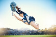 © Jesse Bettencourt/peopleimages.com - Sports, performance and woman cheerleader jumping while performing a routine on the field at an arena. Fitness, exercise and female doing a trick or skill while training or practicing for the show.