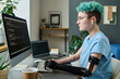 © AnnaStills - Young IT specialist with prosthetic arm concentrating on her online work, she working with security codes