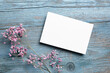 © mikeosphoto - Card mockup, white blank wedding invitation with floral decor on bue wooden background. Greeting card mockup with dried flowers on table