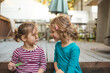 © Cavan Images - two little girls sit happily on a deck in conversation