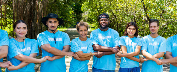 Wall Mural - Team of young and diversity volunteer workers group enjoy charitable social work outdoor in mangrove planting project wearing blue t-shirt while joining hand in assemble unity concept