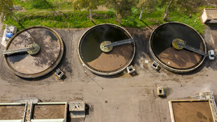 Wall Mural - Aerial view of the tanks of a sewage and water treatment plant enabling the discharge and re-use of waste water. It's a sustainable water recycling with treatment plant.