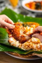 Wall Mural - Indonesian padang food or nasi bungkus with padang fried chicken (indonesian : Ayam goreng padang)