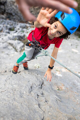 child rock climber gives a high five after passing the track. kids sport and activity.