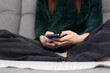 © hurricanehank - Young female person sitting on couch and typing sms message on mobile phone. Unrecognizable girl texting online with modern mobile phone gadget