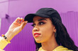 © Dani D.G - Young ethnic woman adjusting cap on street