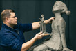 © primipil - Man sculptor creates sculpt bust clay human woman sculpture. Statue craft creation workshop.