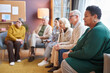 © Seventyfour - Side view at multiethnic group of elderly people watching TV sitting in row together in retirement home