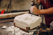 © primipil - Man sculptor creates sculpt bust gypsum human woman sculpture with hammer. Statue craft creation workshop.