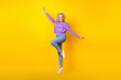 Full size photo of pretty young girl jumping spread hands wings fly plane wear trendy purple clothes isolated on yellow color background