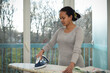 © AUFORT Jérome - mixed race woman ironing at home