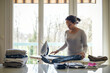 © AUFORT Jérome - mixed race woman ironing at home